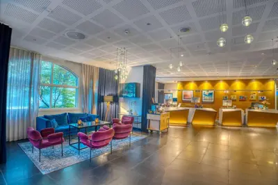 a living room with a blue couch and red chairs at Radisson Blu Royal Hotel, Bergen in Bergen