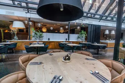 a large wooden table in a restaurant with chairs at Radisson Blu Royal Hotel, Bergen in Bergen