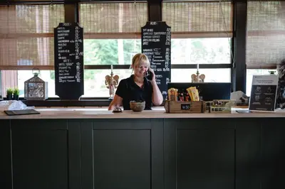 a woman sitting at a counter talking on a cell phone at Trolltun Hotel & Hytter in Dombås