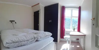 a bedroom with a white bed and a window at Rongahuset BnB in Evanger