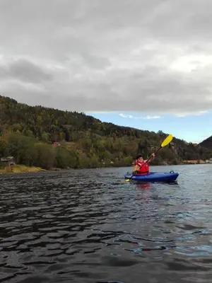 a person in a kayak on a lake at Rongahuset BnB in Evanger