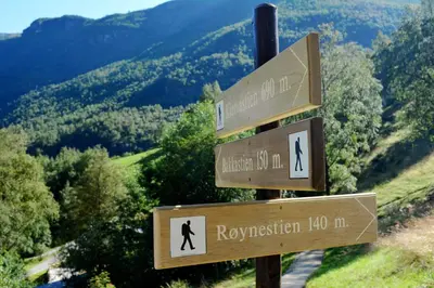a sign for a hiking trail in the mountains at Heimly Pensjonat in Flåm