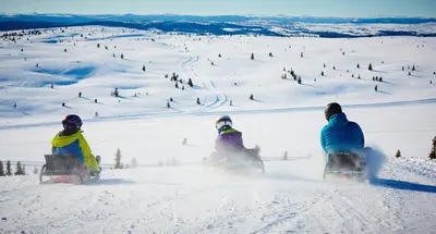 a group of three people riding snowboards in the snow at Storefjell Resort in Gol