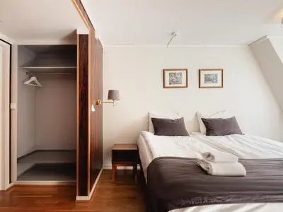 a bedroom with two beds and a closet at Tyssedal Hotel in Tysso