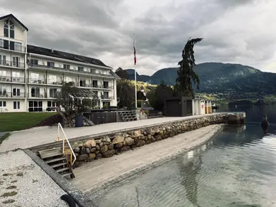 a hotel with a swimming pool in front of a building at Brakanes Hotel in Ulvik