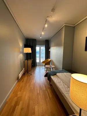 a room with a bed and a table and chairs at Brakanes Hotel in Ulvik