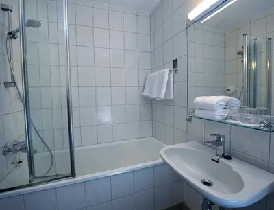 a white bathroom with a sink and a shower at Brakanes Hotel in Ulvik