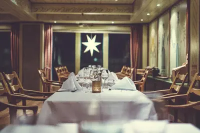 a table in a restaurant with a flag on the wall at Gudbrandsgard Hotel in Kvitfjell