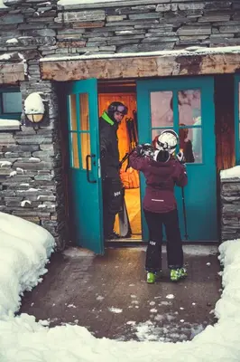 a person standing outside of a door with a snowboard at Gudbrandsgard Hotel in Kvitfjell
