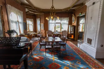 a dining room with tables and chairs and a chandelier at Bårdshaug Herregård in Orkanger