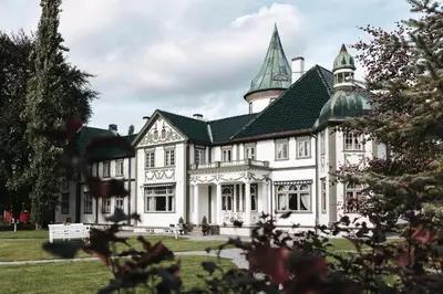 a large white house with a turret at Bårdshaug Herregård in Orkanger