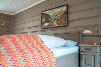 a bedroom with a bed and a painting on the wall at Røisheim Hotel & Skysstasjon in Lom