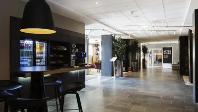 a lobby with a bar and stools in a restaurant at Quality Hotel Grand Kristiansund in Kristiansund