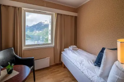 a bedroom with a bed and a large window at Hotel Utsikten - by Classic Norway Hotels in Geiranger