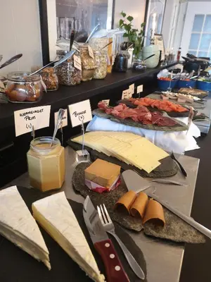 a table with cheese and other foods on a counter at Hotel Utsikten - by Classic Norway Hotels in Geiranger
