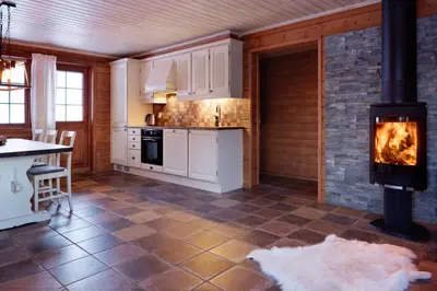 a kitchen with a wood stove in a room at Filefjellstuene hytter og leiligheter in Tyinkrysset