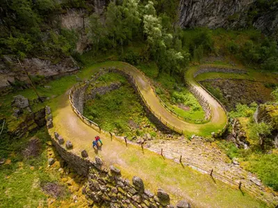 a person riding a bike on a winding mountain road at Filefjellstuene hytter og leiligheter in Tyinkrysset