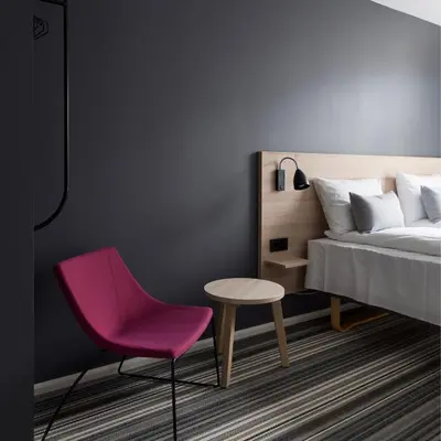 a bedroom with a bed and a pink chair at Citybox Bergen City in Bergen