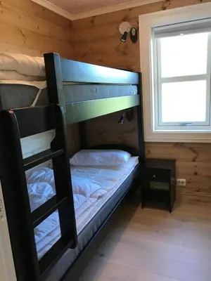 a bunk bed in a cabin with a window at Stranda Fjellgrend in Stranda