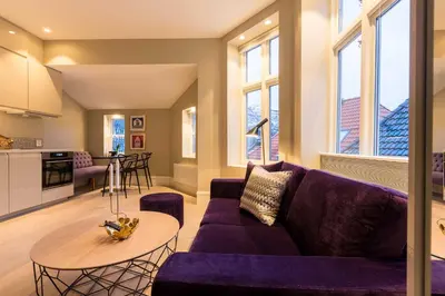 a living room with a purple couch and a table at 2 Døtre Apartments by Hotel Park in Bergen
