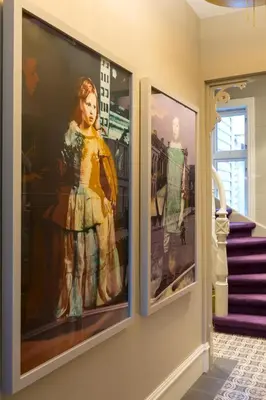 two framed photographs of a woman in a dress on a wall at 2 Døtre Apartments by Hotel Park in Bergen