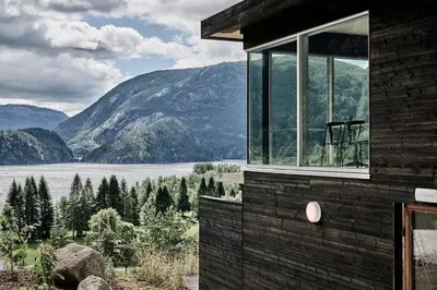 a house with a view of a lake and mountains at Energihotellet in Nesflaten