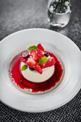 a dessert with strawberries and blueberries on a white plate at Energihotellet in Nesflaten