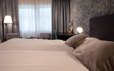a hotel room with a bed and a table at Best Western Tingvold Park Hotel in Steinkjer