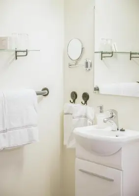 a white bathroom with a sink and a mirror at Gloppen Hotell - by Classic Norway Hotels in Sandane