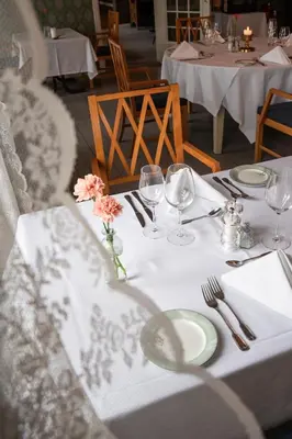 a table with plates and wine glasses on it at Gloppen Hotell - by Classic Norway Hotels in Sandane