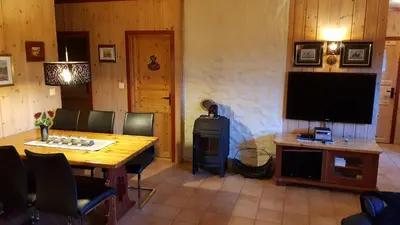 a living room with a wooden table and a television at Solbjørnlia Apartments in Trysil