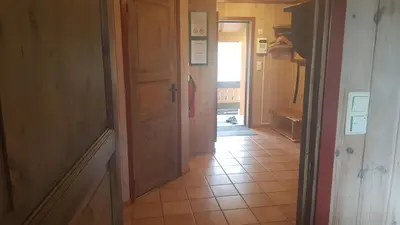 an empty hallway with a door and a tile floor at Solbjørnlia Apartments in Trysil