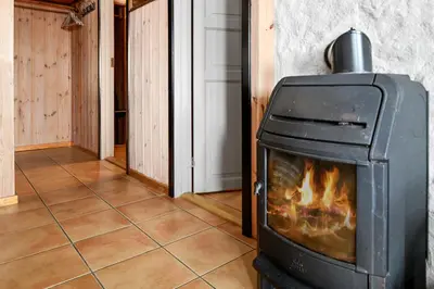 a stove in a room with a fireplace at Solbjørnlia Apartments in Trysil