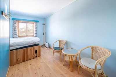 a bedroom with a bed and two chairs and a table at Voss Mountain Lodge in Mjølfjell