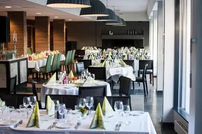 a dining room with tables and chairs with white tablecloths at Hurdalsjøen Hotel & Spa in Hurdal