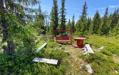 a red bench sitting in the middle of a field at Amazing Home In Sjusjøen With Wifi in Sjusjøen