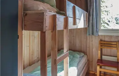 a wooden bunk bed in a room with a window at Amazing Home In Sjusjøen With Wifi in Sjusjøen