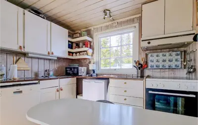 a kitchen with white cabinets and a table in it at Amazing Home In Sjusjøen With Wifi in Sjusjøen