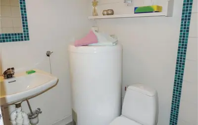 a bathroom with a white toilet and a sink at Amazing Home In Vågå With Kitchen in Vaga
