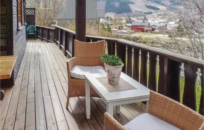 a porch with a table and chairs on a deck at Amazing Home In Vågå With Kitchen in Vaga