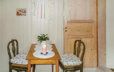 a candle sitting on a table with two chairs at Amazing Home In Vågå With Kitchen in Vaga