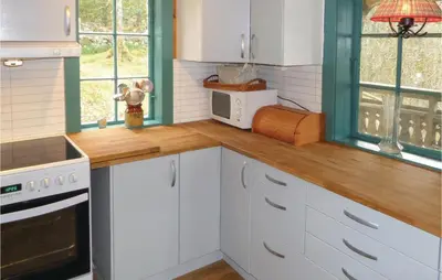a kitchen with white cabinets and a wooden counter top at Stunning Home In Førde I Hordaland in Førde