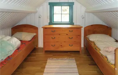 two beds in a room with a window and a dresser at Stunning Home In Førde I Hordaland in Førde