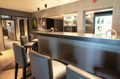 a bar with chairs and a counter in a restaurant at Grand Hotel Skei - Unike Hoteller in Skei
