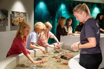 a group of women standing around a bathtub with food at Hotel Noreg in Ålesund