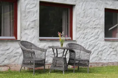 two chairs and a table with a vase of flowers at Smedsgården Hotel in Nesbyen