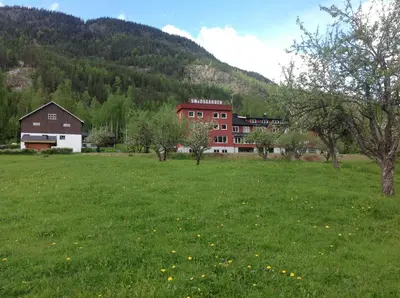 a field of green grass with a building in the background at Smedsgården Hotel in Nesbyen