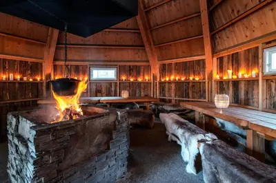 a large room with a fireplace and wooden walls at Thon Hotel Bjørneparken in Flå