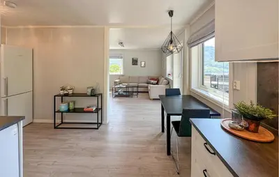 a kitchen and a living room with a table at 5 Bedroom Awesome Home In Etne in Erve