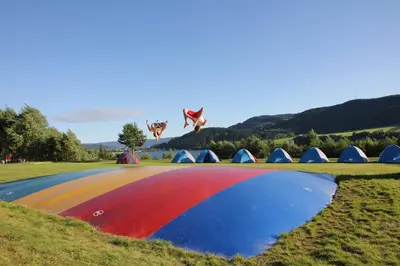 a group of tents in a field with a rainbow at Lillehammer Turistsenter Budget Hotel in Lillehammer